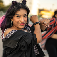 photo of a group of hispanic teens dancing hip hop with the focus on a female with a mischievous smile